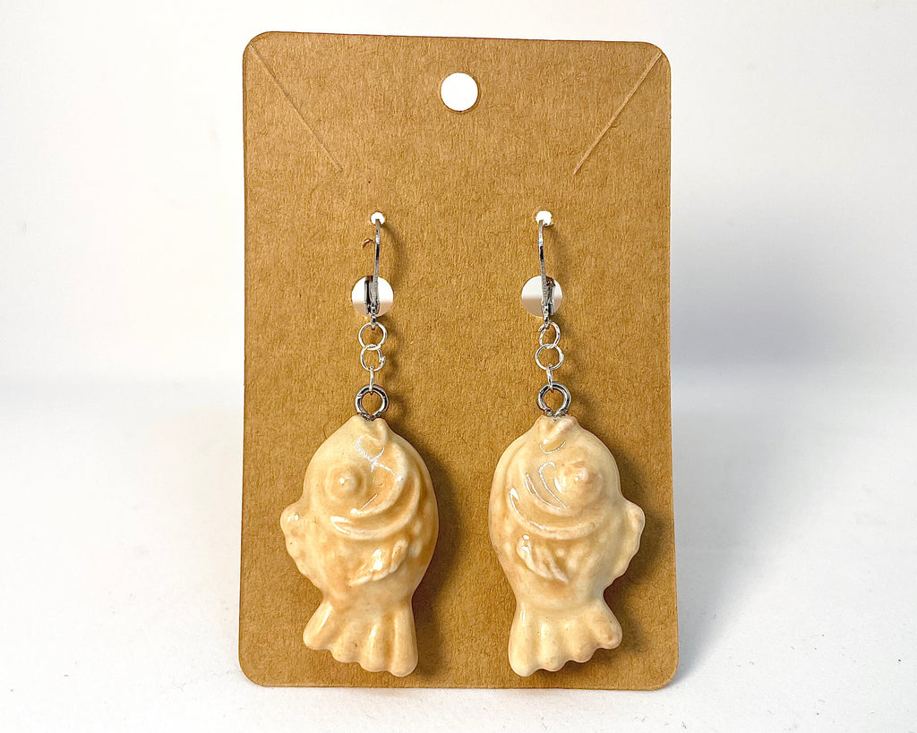 Pair of Taiyaki earrings on a beige card with a white background