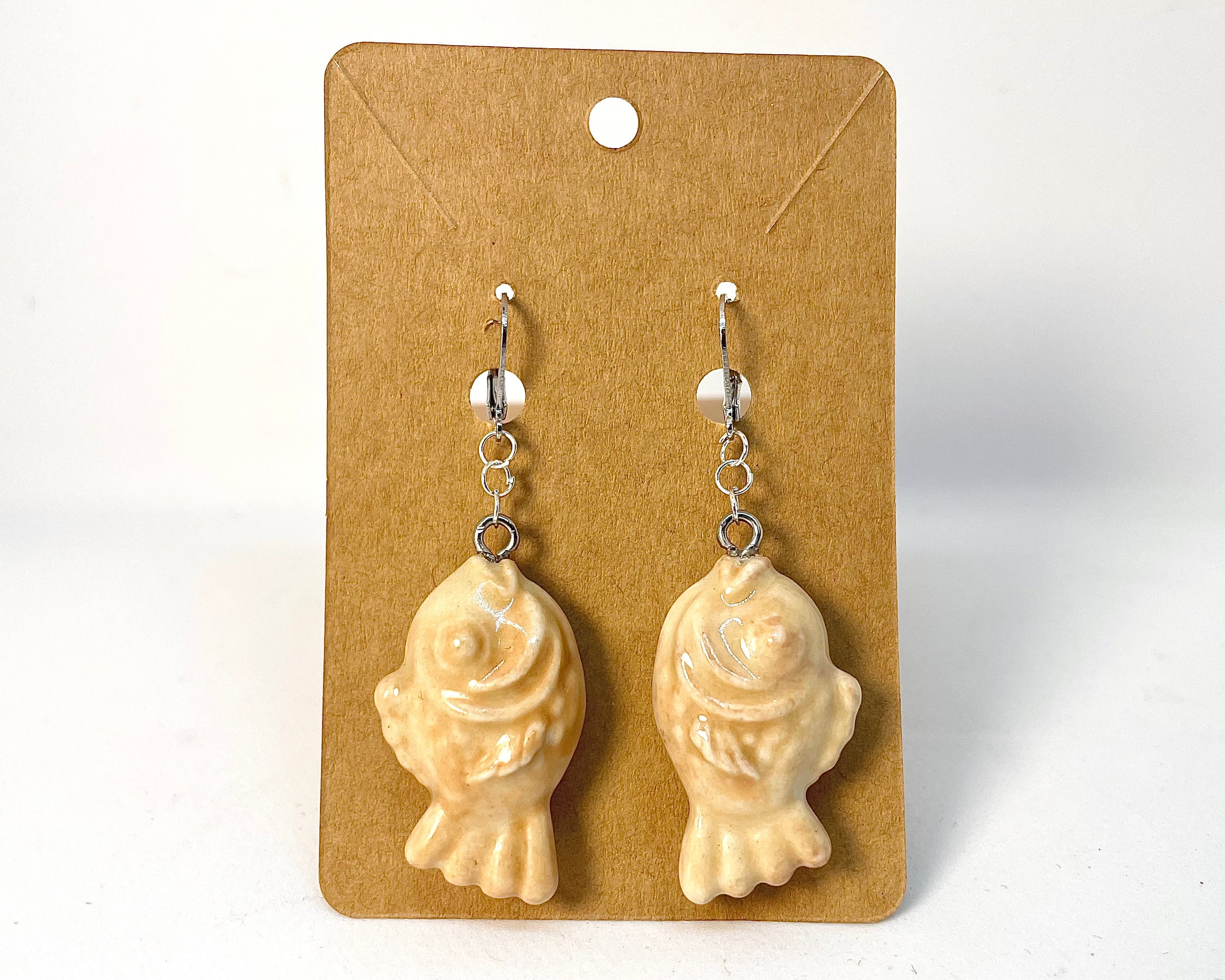 Pair of Taiyaki earrings on a beige card with a white background