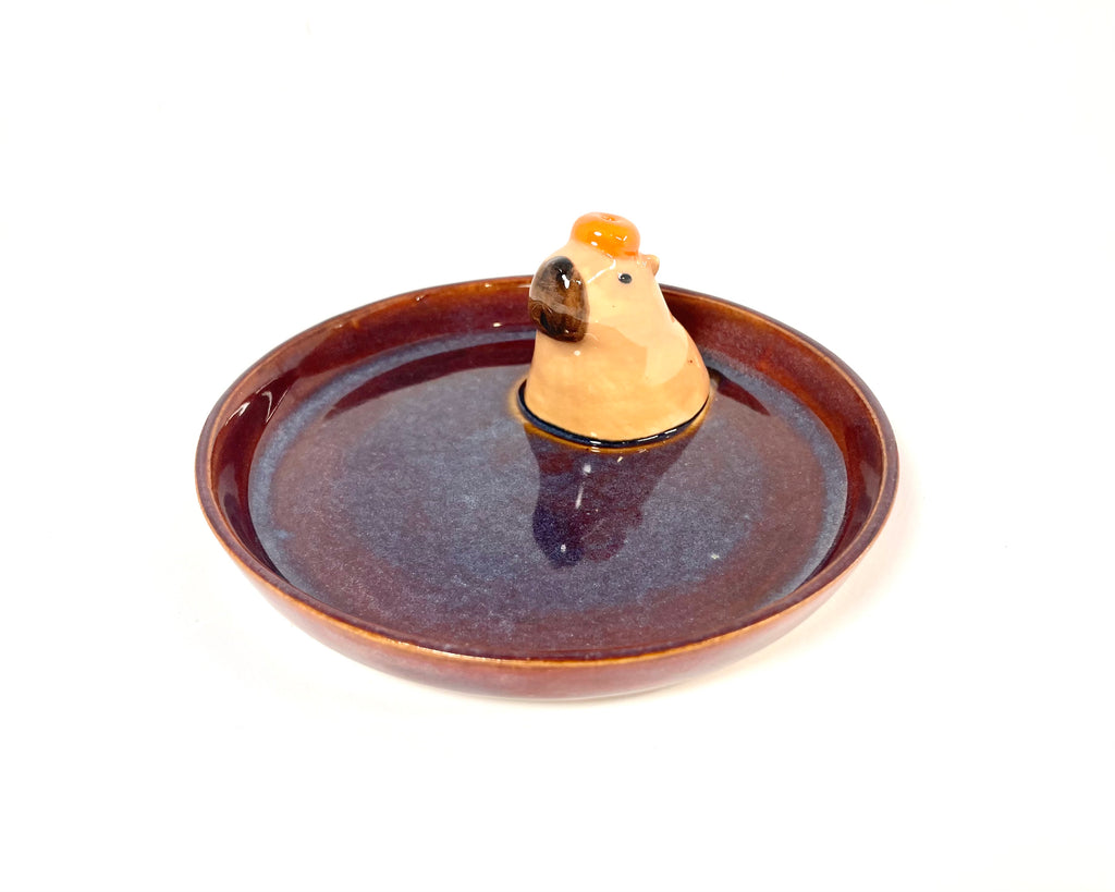 Relax with this charming handmade capybara incense holder and trinket dish. Perfect for holding jewelry or burning your favorite incense, this ceramic piece adds a touch of "kawaii" to your home.
