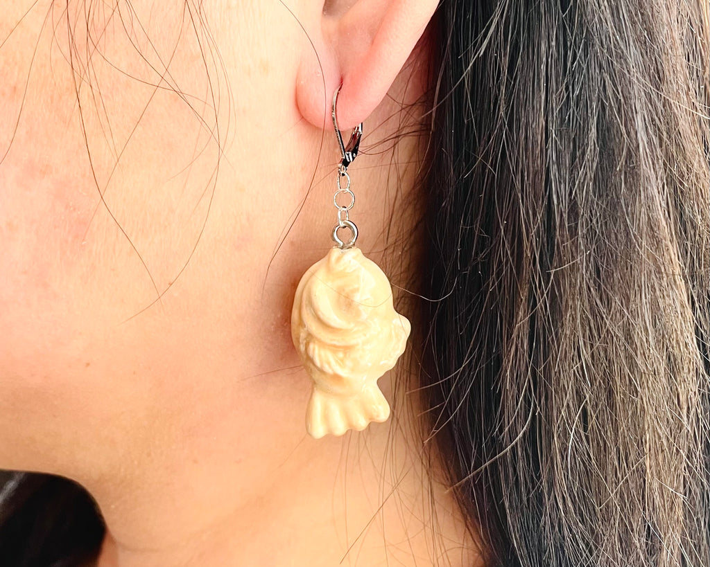 Taiyaki earrings worn by a person with dark hair.