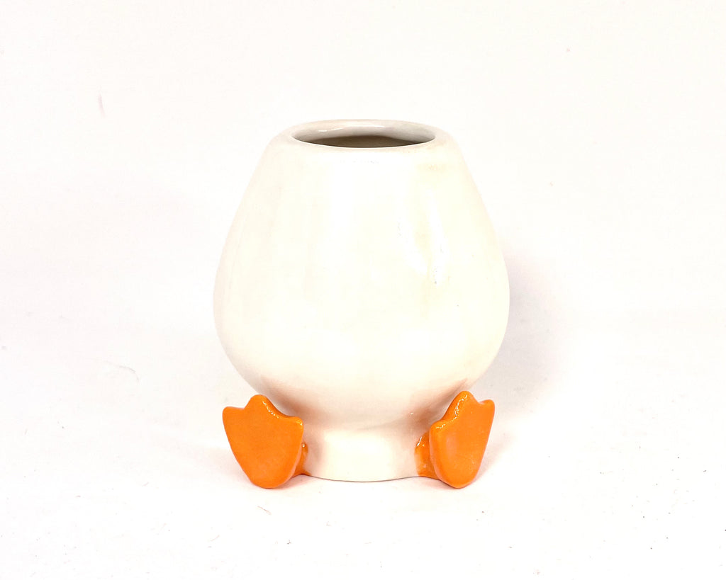 White ceramic chasen holder with orange feet on a white background