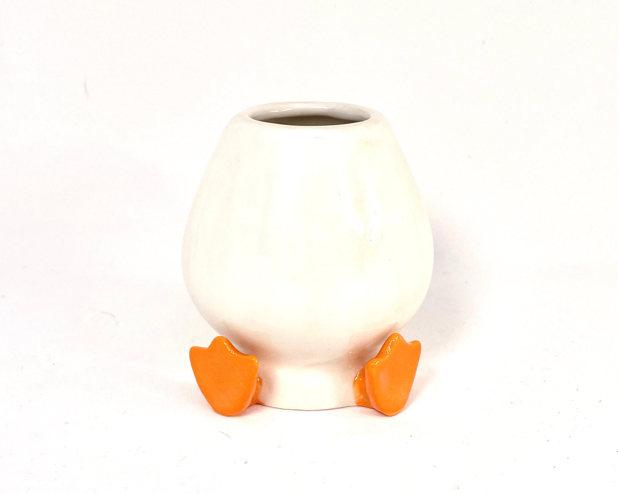 White ceramic chasen holder with orange feet on a white background