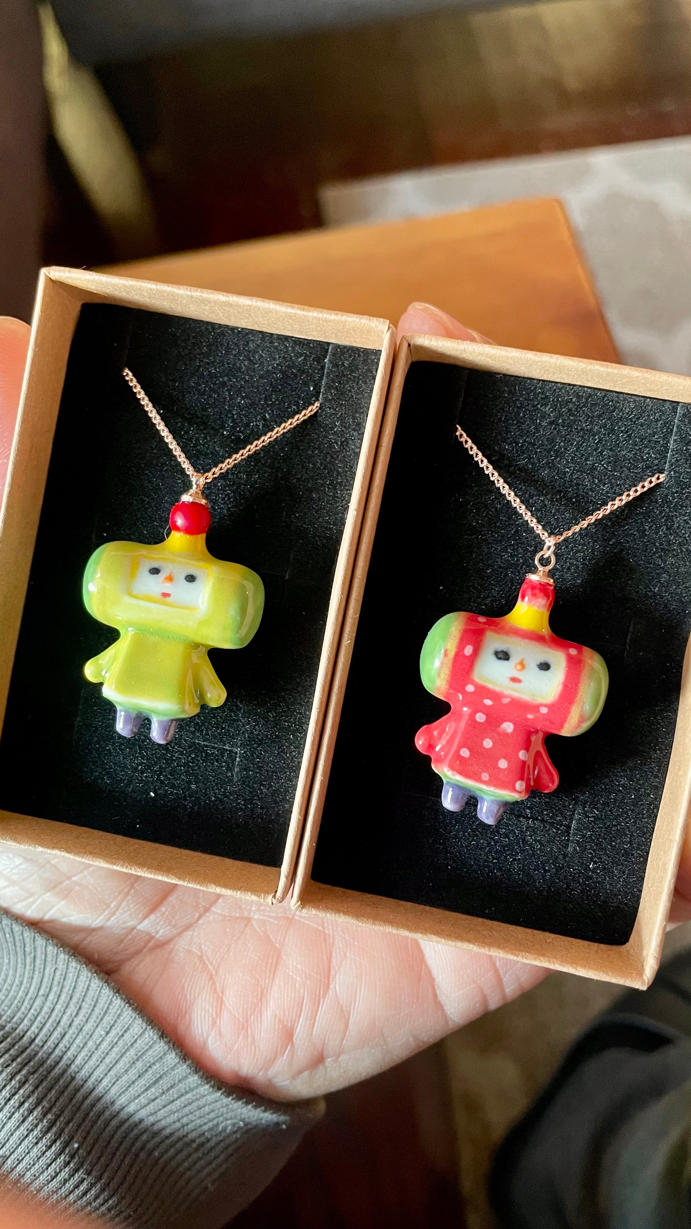 Close-up of a hand-sculpted white porcelain Katamari charm featuring the iconic Prince character.